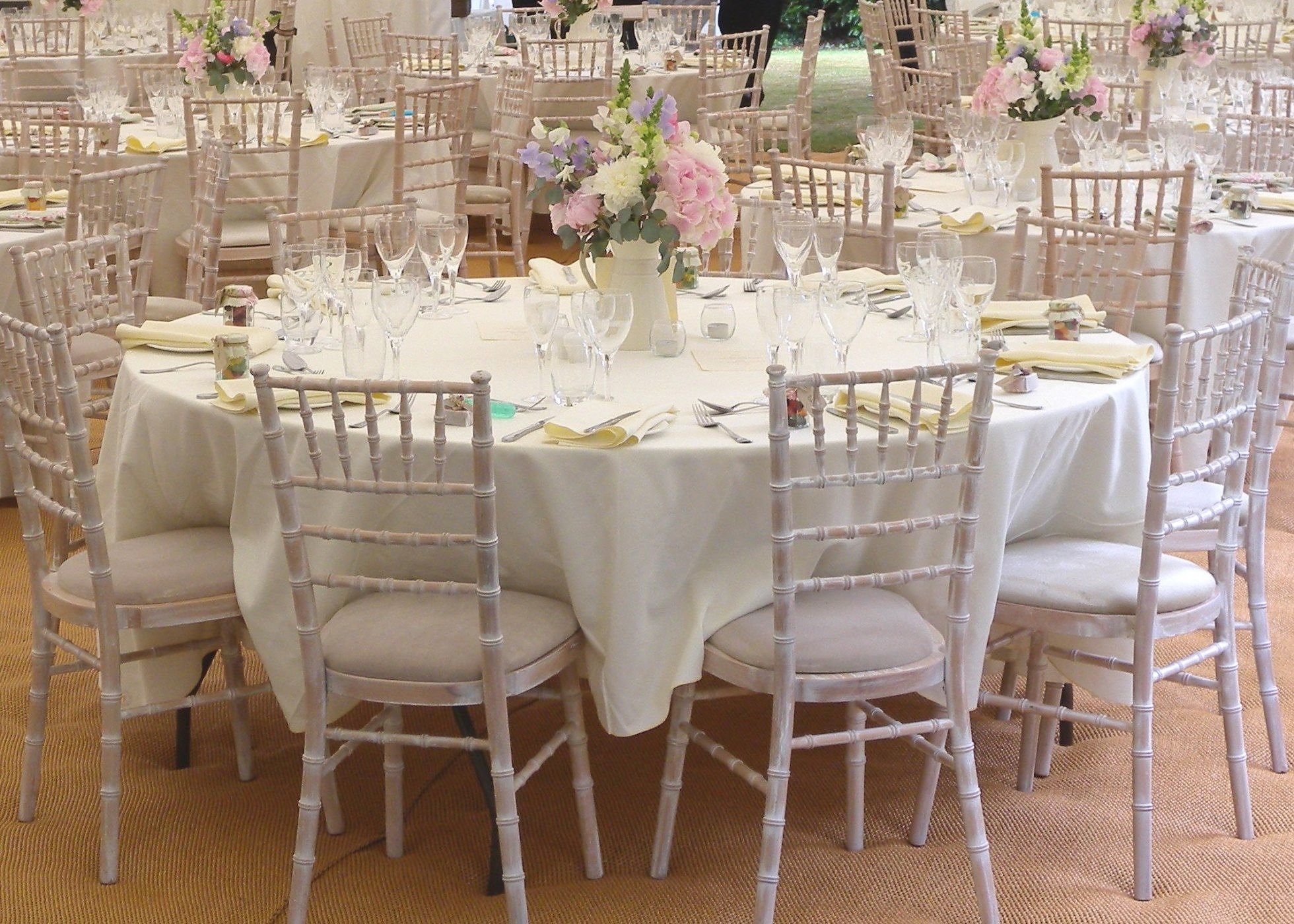 Interior shot of Wedding marquee table setting with Limewash Chiavari chairs and table centres with sweet pea flowers