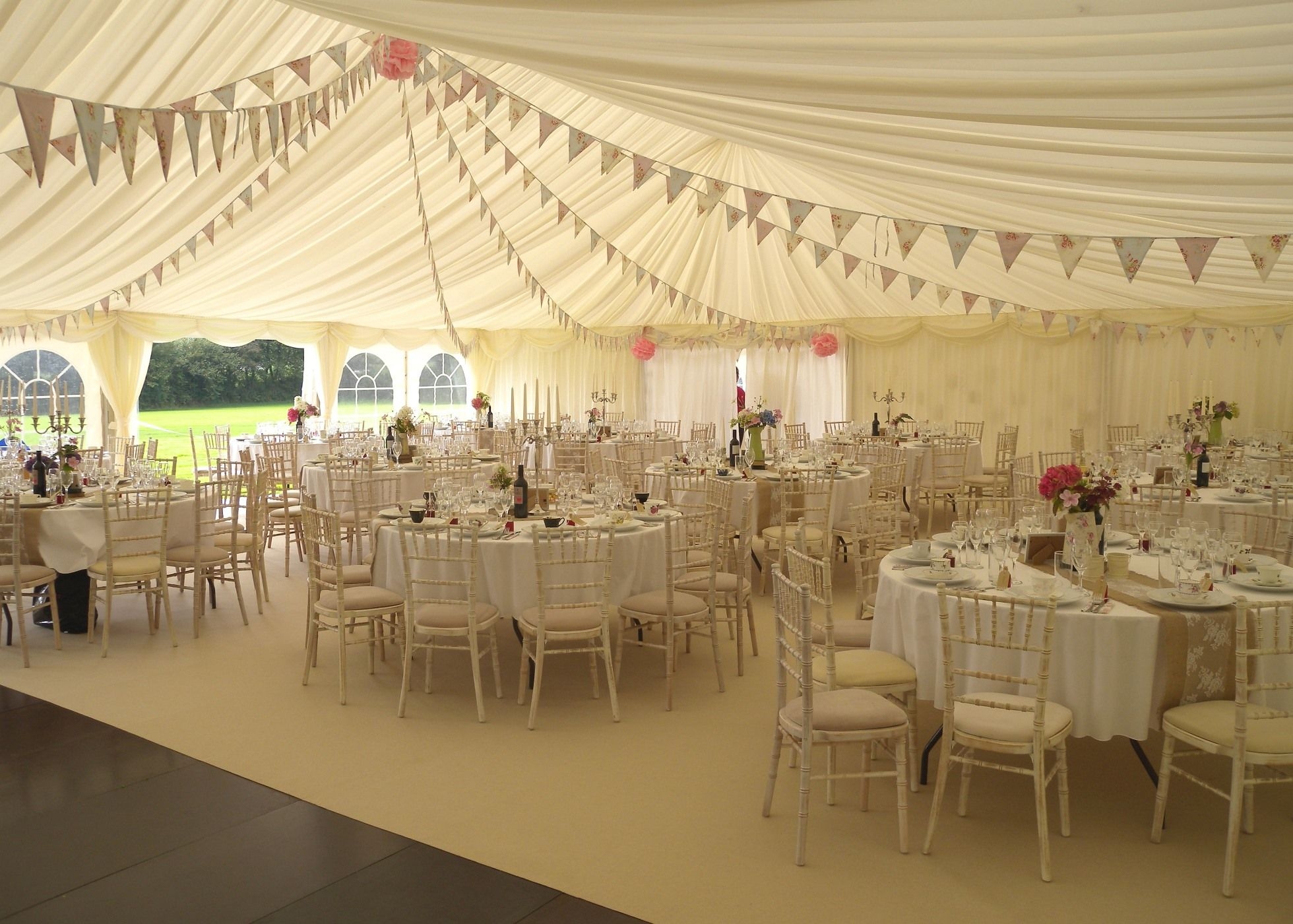 Wedding Marquee beautiful interior featuring bunting, candelabras, wooden flooring and carpet