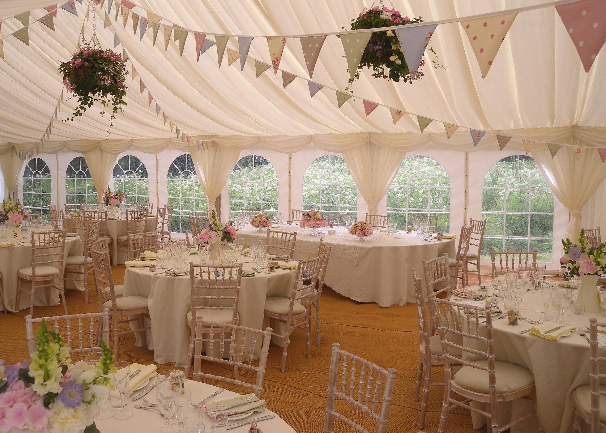 Interior photo of wedding marquee with bunting and hanging baskets