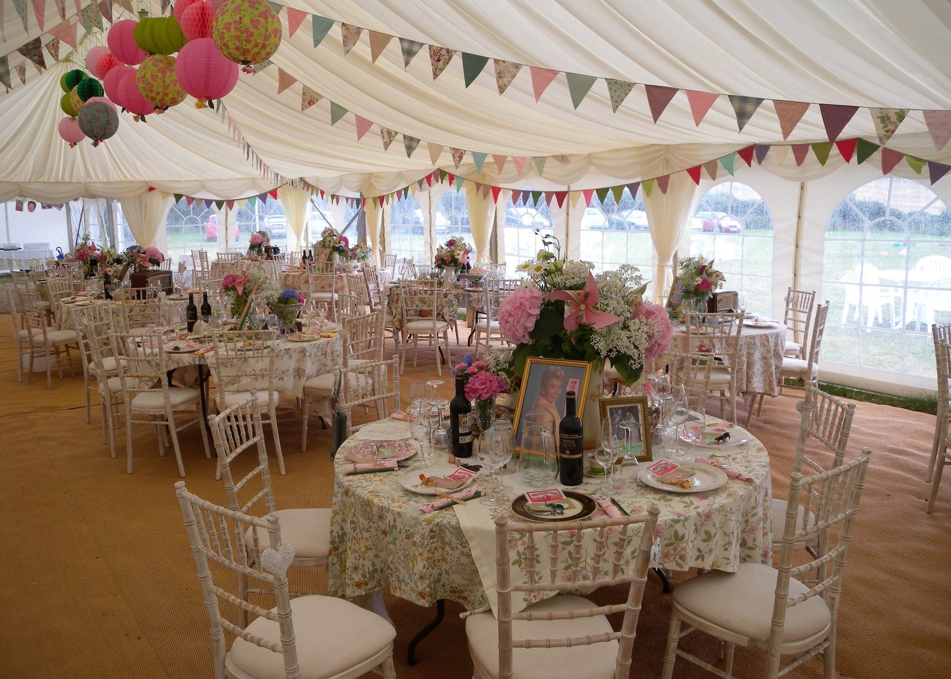 Wedding Marquee interior with vintage, 1950s style table settings, bunting and paper lanterns